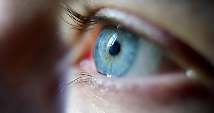 Close-up macro shot of young male human blue eye blinking in slow motion. Concept of moments of life, memory, eye care, optics., lens. Shot with RED 8K