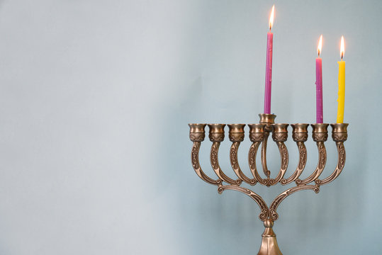 Second day of Hanukkah with burning Hanukkah colorful candles in Menorah (traditional Candelabra) .Chanukkah-jewish holiday. Each night, another candle is added. Copy space for text.