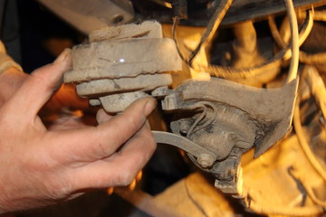 Men's rough hands hold the rusted electrical car horn - old vehicle repair
