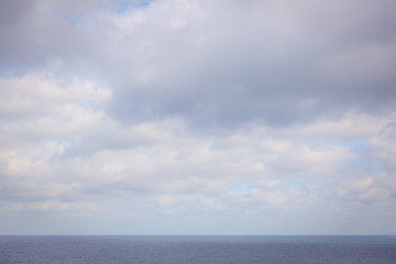 Naklejka na ściany i meble View of the sea, horizon line, clouds and blue sky. Sea water and sky horizon line