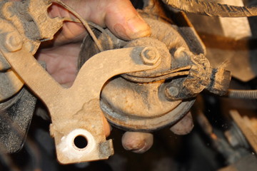 Men's rough hands hold the rusted electrical car horn - old vehicle repair
