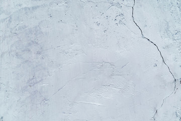 Natural background. Wall with a shabby and peeling paint, crack and plaster.  gray and white