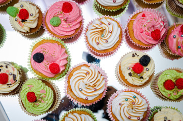 group of tasty cupcakes on a white wooden table