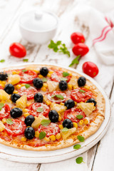Pizza with tomatoes, mozzarella cheese, olives, corn and basil. Traditional italian cuisine