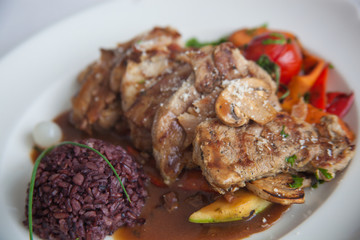 pork with rice and vegetables on white plate