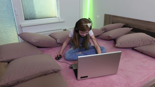 Girl is sitting in bed with a laptop