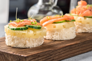 Bruschetta toast of white bread with slices of pineapple cucumber fish salmon fresh green sprouts