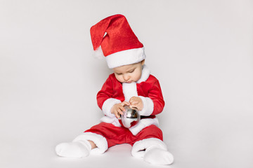 Cute little toddler girl wearing Santa costume photographed over white background.