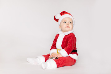 Cute little toddler girl wearing Santa costume photographed over white background.