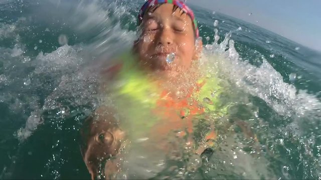 boy on pedal boat pulls off the hill into the sea, view from water, outdoors