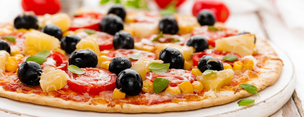 Pizza with tomatoes, mozzarella cheese, olives, corn and basil. Traditional italian cuisine. Banner