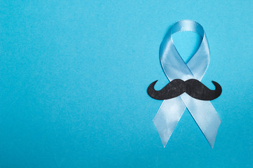 Blue ribbon with a mustache. Symbol of prostate cancer. Copy space. 