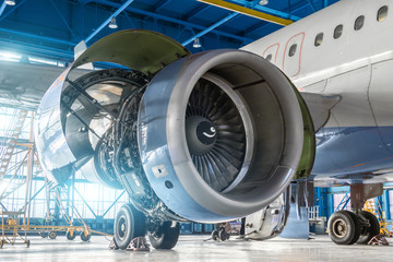 Aircraft engine jet on the wing during maintenance in the hangar. - obrazy, fototapety, plakaty