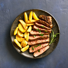 Medium rare roast beef with potato wedges