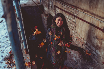 Girl walking around the city in the ghetto in the winter. Jumpsuit and scarf, street style concept