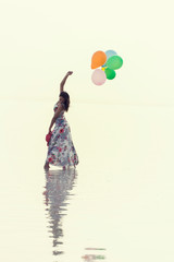 motivation or hope concept, follow your dream and inspiration, girl with balloons at sunset