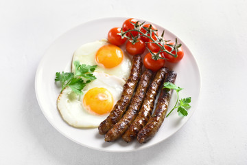 Fried eggs, sausages and cherry tomatoes