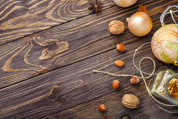 Obraz na płótnie Canvas Christmas balls decor and nuts on old wood background with empty place for text
