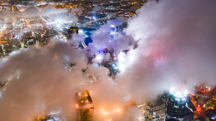 Clouds hovering over skyscrapers at night