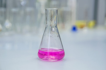 Laboratory glassware with liquid on table. Chemical analysis