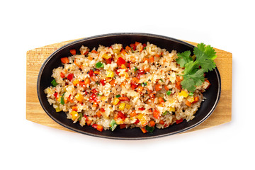 Top view pan of traditional Japanese rice with vegetables at wooden board isolated at white background.