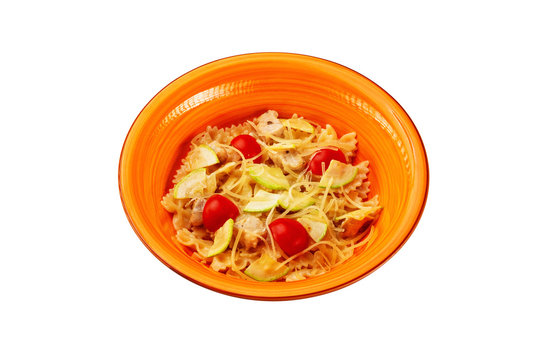 Closeup plate of tripolini italian pasta with tomato, cucumber and chicken isolated at white background.
