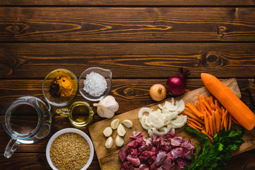 ingredients meat with rice cooking on a wooden table