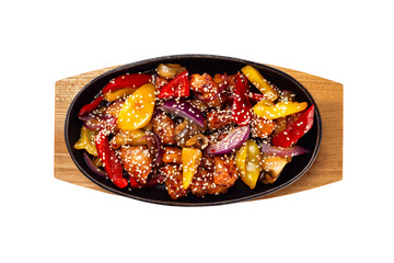 Pan of fried chicken with pineapple and grilled vegetables - pepper and onion served with sesame and teiyaki sauce at wooden board isolated at white background.