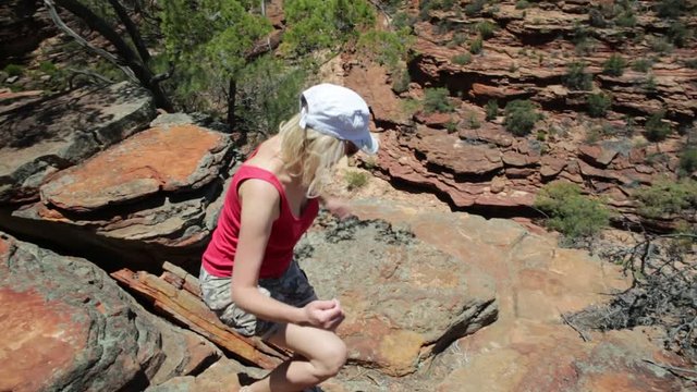 Happy blonde woman enjoying at Z-Bend lookout to Murchison River in Kalbarri National Park, Western Australia. Freedom caucasian traveler in outback of Australia. Blue sky, summer season. Copy space.