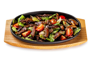 Pan of grilled beef and vegetables served with teiyaki sauce at wooden board isolated at white background.