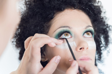 Obraz premium Brunette with green eyes doing makeup