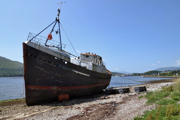 Abandoned vintage fishing boat on beach near Corpach village, Fort William, Scotland, United Kingdom, sunny summer day