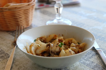 plate of cuttlefish and sunglasses on the table of a french restaurant