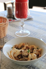 plate of cuttlefish and sunglasses on the table of a french restaurant