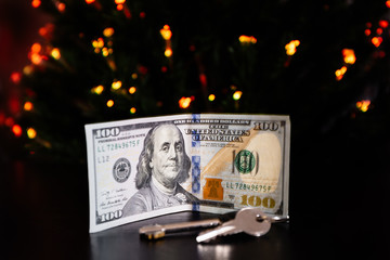 Key and banknote United States One Hundred Dollar under the new year tree