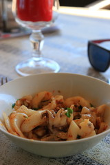 plate of cuttlefish and sunglasses on the table of a french restaurant