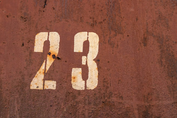 background. rusty industrial sheet metal with the number 23 beige