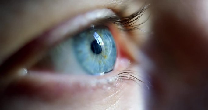 Close-up macro shot of young male human blue eye blinking in slow motion. Concept of moments of life, memory, eye care, optics., lens. Shot with RED 8K