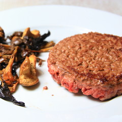 plate of forest mushrooms with a chopped steak