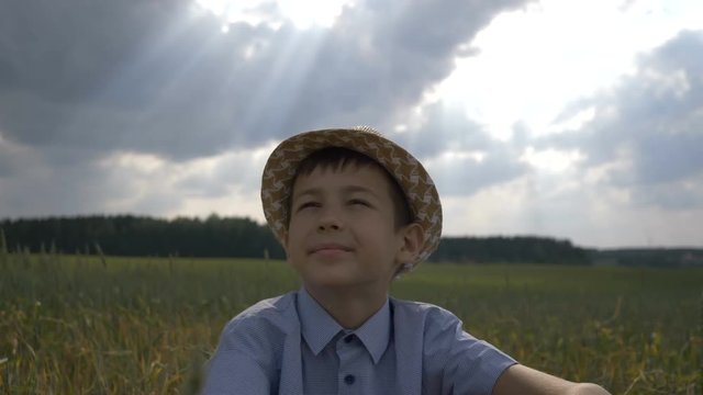 dreamer boy in the hat looks at the beautiful sky