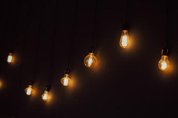 Set of vintage glowing light bulbs on black background.Tungstens lights bulbs on black background...