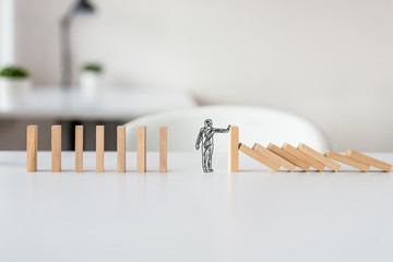 Hand drawn shape of businessman stopping domino effect - obrazy, fototapety, plakaty