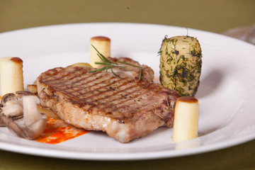 pork chop with vegetables on a white plate