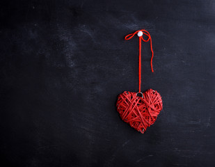 small wicker red heart hangs on a rope