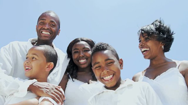 Portrait of happy African American family making video diary on their beach holiday RED EPIC