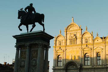 The Scuola Grande di San Marco is a building in Venice, Italy. In the foreground, in the shade, the equestrian monument dedicated to Bartolomeo Colleoni.