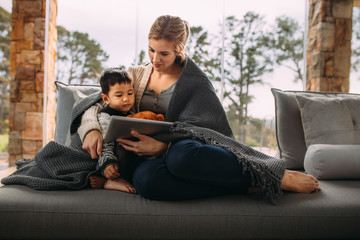 Obraz premium Mother and son with digital tablet in the living room