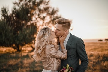 Stylish wedding photo shoot in nature at sunset.