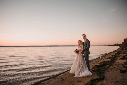 Stylish wedding photo shoot in nature at sunset.