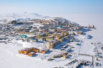 Winter landscape with the northern city of Anadyr. The administrative center of Chukotka and the most eastern city of Russia. Aerial photography of a small arctic city with colorful buildings. 